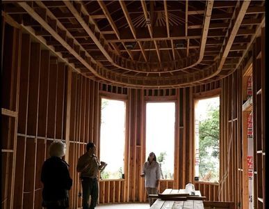 Unfinished room with wooden beams and windows.